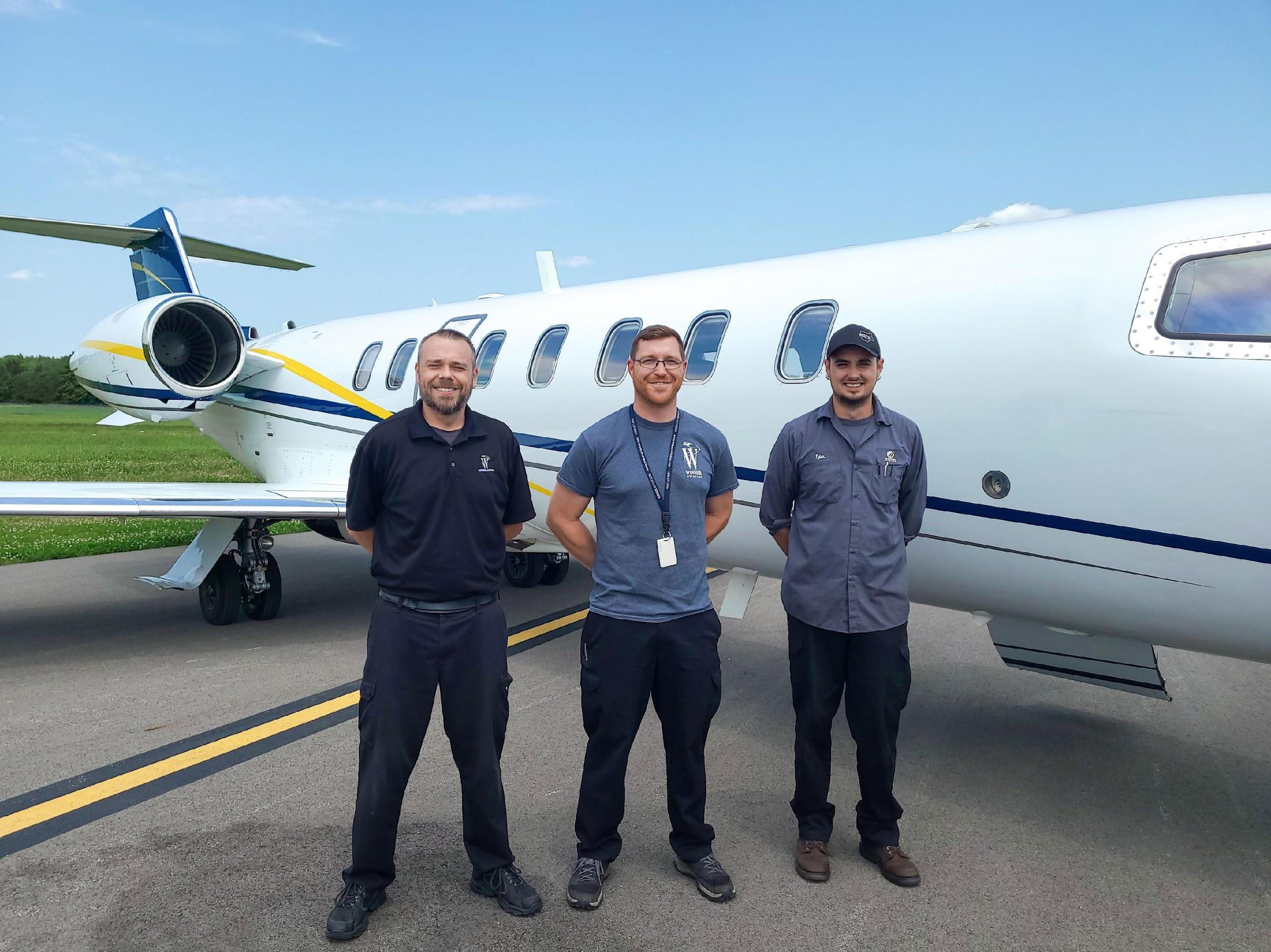 JETS aircraft management team in front of a managed aircraft