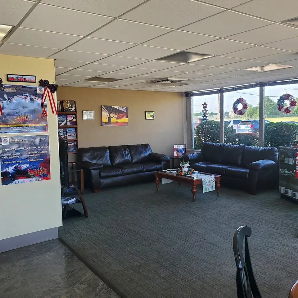 KLPR lobby and crew lounge with two black leather sofas, a coffee table, and large windows