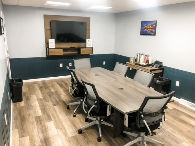 JETS FBO North conference room with table, chairs, and TV