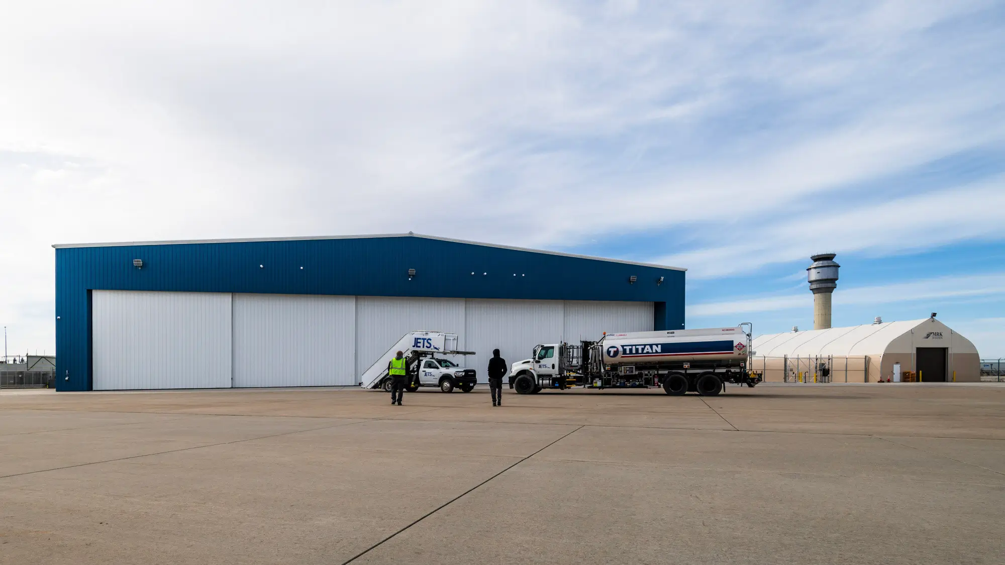 JETS South Hangar exterior with JETS service vehicle and Titan fuel truck on the ramp