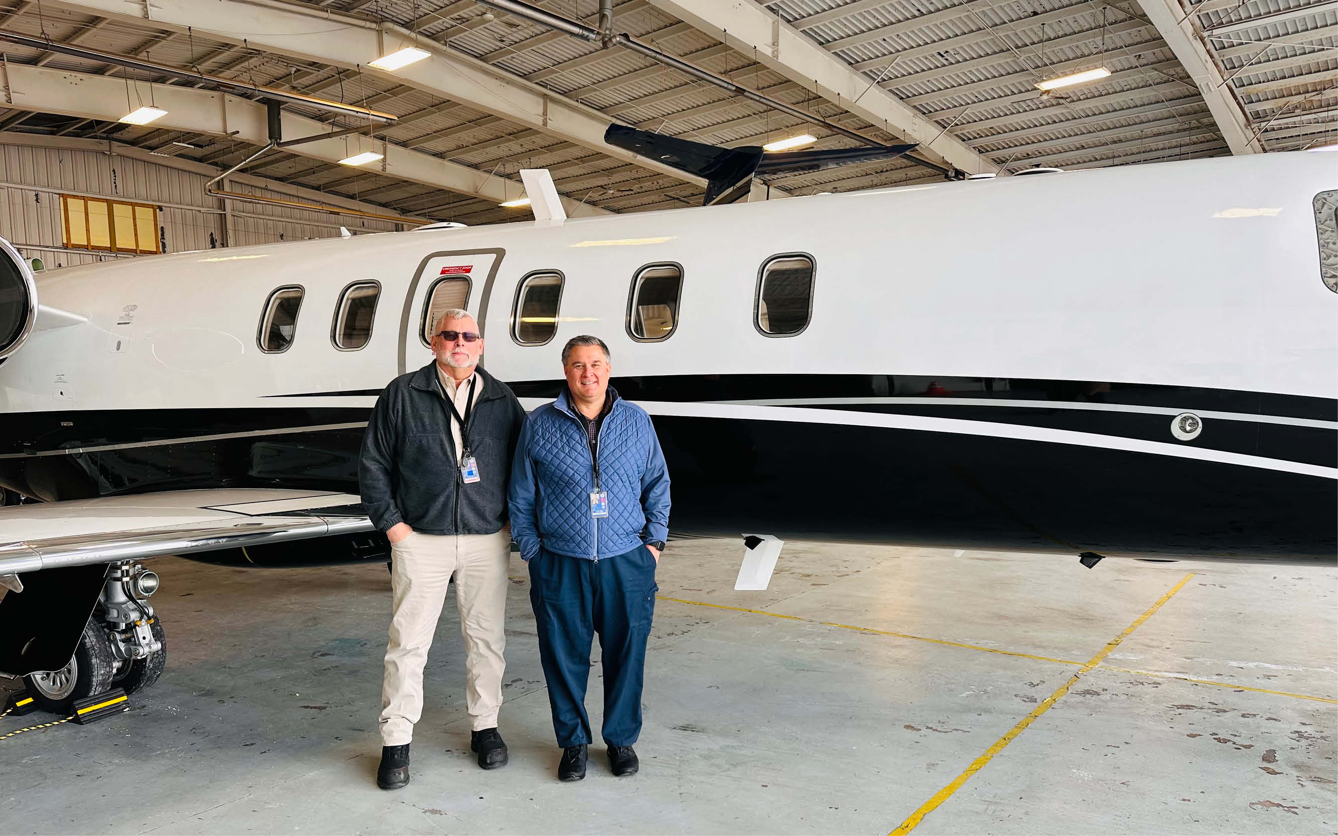 Doug McConnell and Mike Hillman in front of a managed private jet